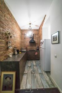 a kitchen with a refrigerator and a brick wall at Loft Style Apartment in Tbilisi City