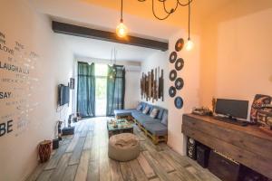 a living room with a blue couch and a tv at Loft Style Apartment in Tbilisi City