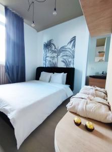 2 Betten in einem Schlafzimmer mit blauen Wänden und Palmen in der Unterkunft L'appart by Authentic in Saint-Ghislain