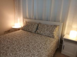 una camera da letto con un letto con due lampade sopra di Villa Roccia Scura dell'Etna a Zafferana Etnea