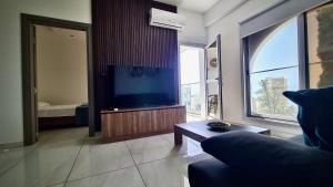een woonkamer met een bank en een flatscreen-tv bij 351 Turquoise Oasis in Limassol