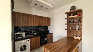 a kitchen with wooden cabinets and a washer and dryer at 351 Turquoise Oasis in Limassol +5 photos