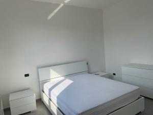 Dormitorio blanco con cama blanca y armarios blancos en Casa vacanze Marinella en Bagnara Calabra