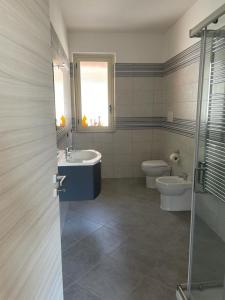 baño con lavabo y aseo y ventana en Casa vacanze Marinella en Bagnara Calabra