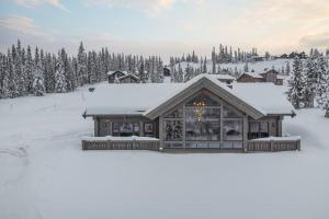 a house in the snow with snow at Hyttekos Lodge: luxury ski-in/ski-out chalet in Kvitfjell