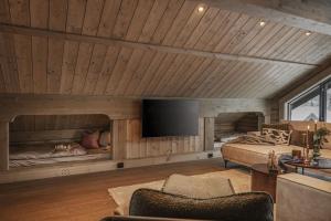 a room with two beds and a flat screen tv at Hyttekos Lodge: luxury ski-in/ski-out chalet in Kvitfjell