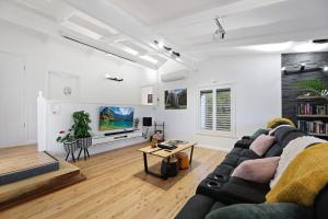 a living room with a couch and a tv at The Smart Retreat in Katoomba