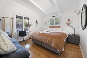 a bedroom with a large bed and a blue couch at The Smart Retreat in Katoomba