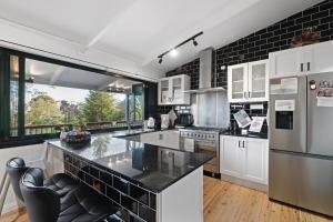 a kitchen with white appliances and a large window at The Smart Retreat in Katoomba