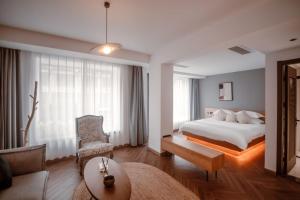 a hotel room with a bed and a couch at Yiwu Holly Hotel in Yiwu