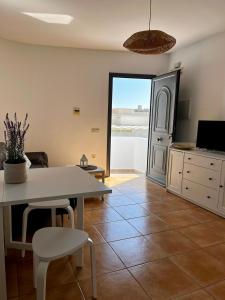 a living room with a table and chairs and a window at Las Hélices San José Cabo de Gata in San José