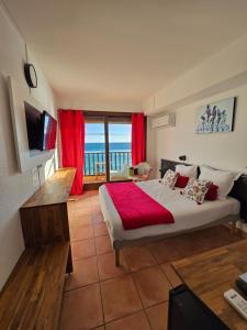 a bedroom with a bed and a view of the ocean at Hotel Chanteplage in Saint-Cyr-sur-Mer