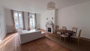 ein Wohnzimmer mit einem Sofa und einem Tisch in der Unterkunft Appartement standing coeur de Vendôme Caroline Paul Officiel in Vendôme