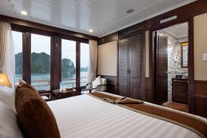 Schlafzimmer mit einem großen Bett und Blick auf das Wasser in der Unterkunft Hạ Long Aqua Legend Cruise in Hạ Long
