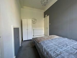 an empty bedroom with a bed and a closet at Howburn Place in Aberdeen