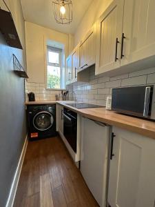 a kitchen with a washer and dryer in it at Howburn Place in Aberdeen