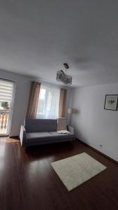 a living room with a couch and a window at Apartament Râșnov in Râşnov