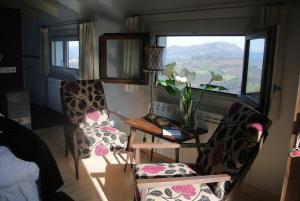 um quarto com duas cadeiras, uma mesa e uma janela em Hotel Rural El Algaire em Arquera de Sales