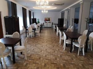 une salle à manger avec des tables et des chaises ainsi qu'un lustre dans l'établissement Carmen, à Głogów