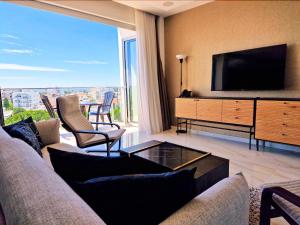 a living room with a couch and a tv at Sveltos Residence Suites in Larnaca