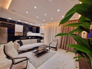 a living room with a white couch and chairs at Sveltos Residence Suites in Larnaca +76 photos