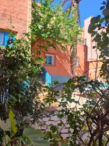 un edificio con alberi di fronte di Maison d'hôtes Retour Au Calme a Tinerhir
