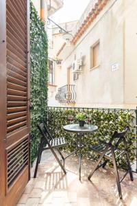 een patio met een tafel en stoelen op een balkon bij BOHEMIAN - Taormina Central Apartment in Taormina