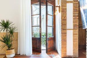 an open wooden door in a room with a window at BOHEMIAN - Taormina Central Apartment in Taormina