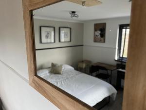 um reflexo de um quarto com uma cama num espelho em Scottish Nest in the heart of East Kilbride 10mins from Hairmyres Hospital em East Kilbride