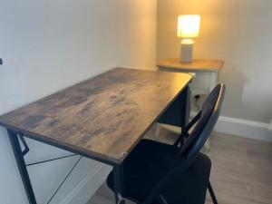 a wooden desk with a chair and a lamp at Scottish Nest in the heart of East Kilbride 10mins from Hairmyres Hospital in East Kilbride