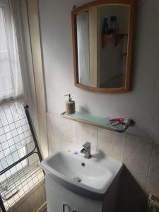 y baño con lavabo blanco y espejo. en Bromley Cosy, en Bromley