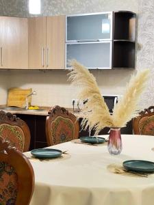 een keuken met een tafel met veren bij NURLY TAU APARTMENTS in Alma-Ata