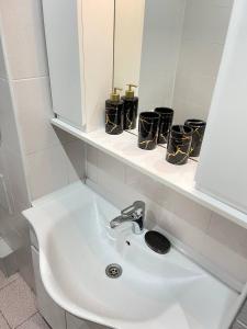 een badkamer met een wastafel en een spiegel bij NURLY TAU APARTMENTS in Alma-Ata