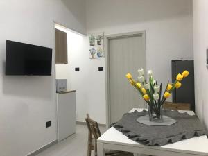 a dining room with a table with a vase of yellow flowers at One bedroom apartement with balcony and wifi at Ribera in Ribera