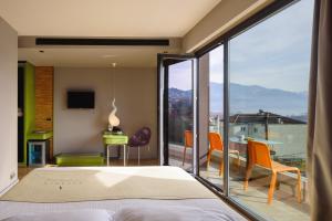 Un dormitorio con una cama y un balcón con vistas. en Essence Hotel, en Ioannina