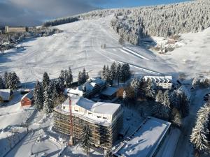 上維森塔爾溫泉鎮的住宿－Summit of Saxony Resort Oberwiesenthal，雪中建筑物的空中景观