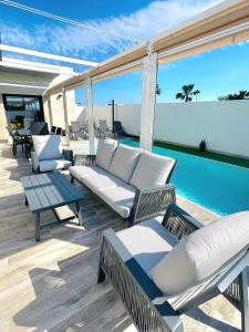 eine Terrasse mit weißen Möbeln und einem Pool in der Unterkunft Casa XtelBen in Daya Nueva