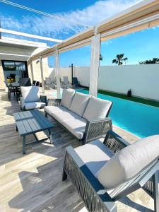 a patio with white furniture and a swimming pool at Casa XtelBen in Daya Nueva