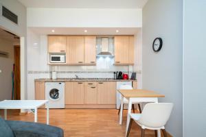 a kitchen with wooden cabinets and a table and chairs at Apartamentos GO Covaresa -Parking Gratuito in Valladolid