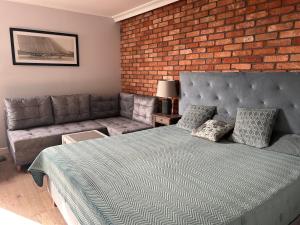 a bedroom with a bed and a brick wall at Apartament Anna in Sopot