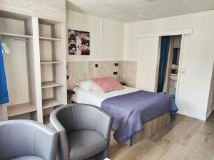 ein kleines Schlafzimmer mit einem Bett und einem Stuhl in der Unterkunft Hotel Sfinx in De Panne