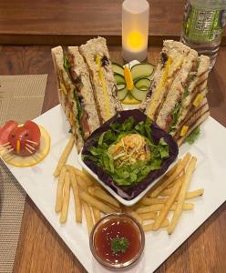 a plate of sandwiches and french fries on a table at Queensland Hotel in Nuwara Eliya