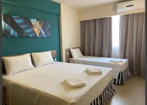 une chambre d'hôtel avec deux lits et un mur bleu dans l'établissement Apto em resort Solar das Águas, à Olímpia 17 autres photos