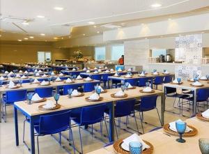 une salle à manger avec des tables et des chaises bleues dans l'établissement Apto em resort Solar das Águas, à Olímpia