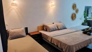 a bedroom with two beds and lights on the wall at Urban Farmhouse in Siem Reap