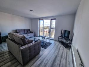a living room with a couch and a television at Elegant City Apt: 1-BR Luxury in Wolverhampton