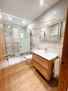 uma casa de banho com um lavatório, um chuveiro e um WC. em Apartamento San José em Milladoiro