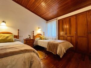 a bedroom with two beds and a wooden ceiling at Finca León in Santa Brígida