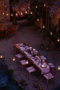 a long table with candles and chairs and lights at Macaron Konagi in Ayvalık