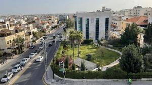 una calle de la ciudad con coches aparcados en la carretera en Abdoun Apartment, en Amán